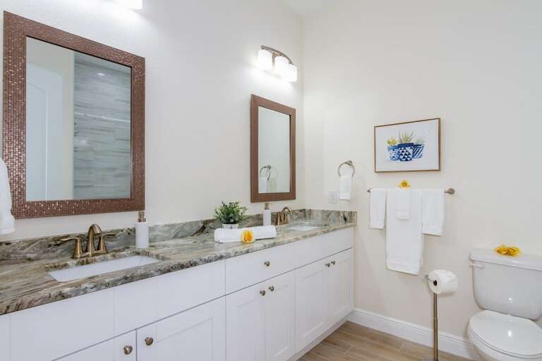 The guest bathroom is shared between the two guest bedrooms and features dual sinks and a walk in tub