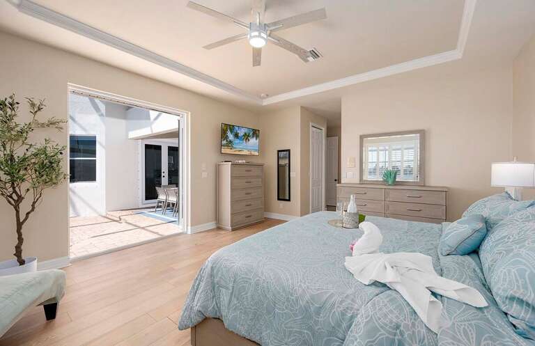 Main Bedroom With King Bed and French Doors Offering Access To Pool Area