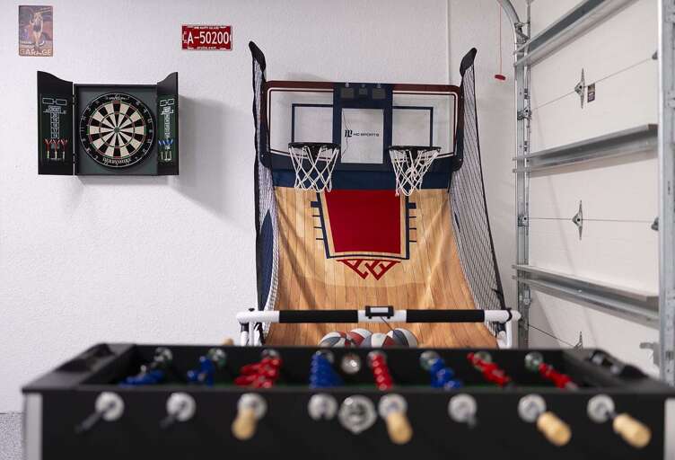 Garage is Converted into a Game Room with Ping Pong Table, Foosball Table as well as and Indoor Basketball  and Dart Board