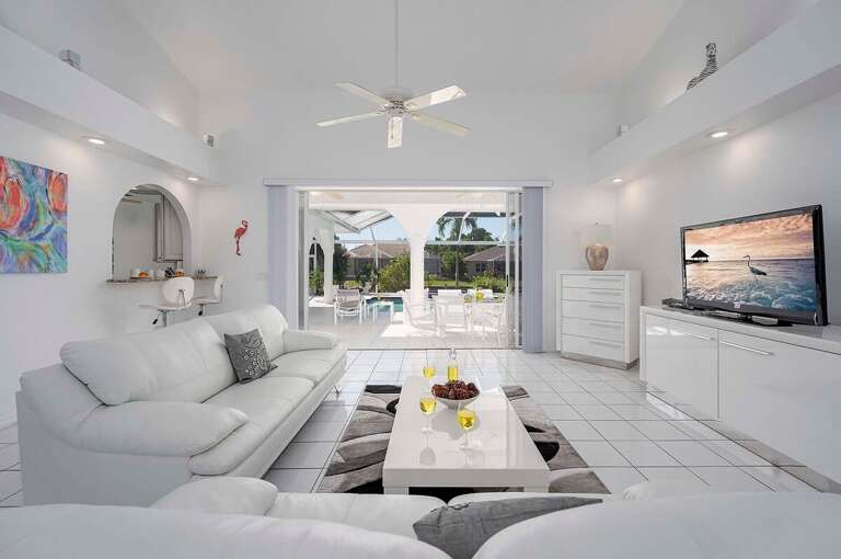 Modern Living Room with Leather couches and an Unobstructed View of the Tropical Pool