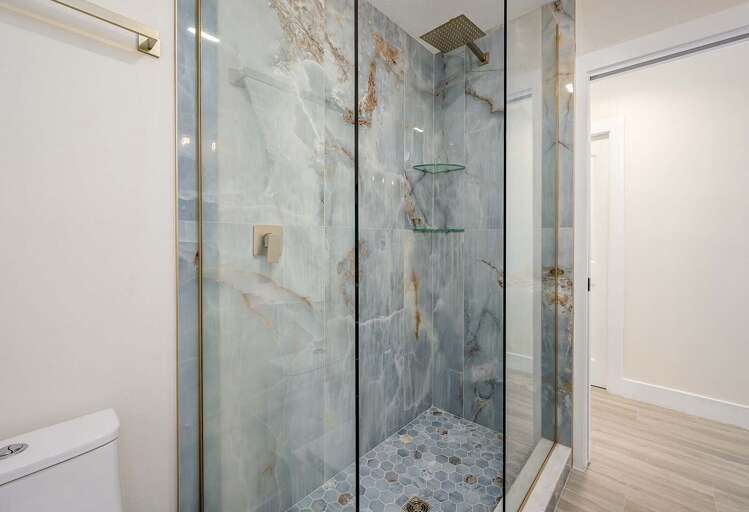 Glass Shower in Main Bathroom featuring and Impressive Marble Slab Wall