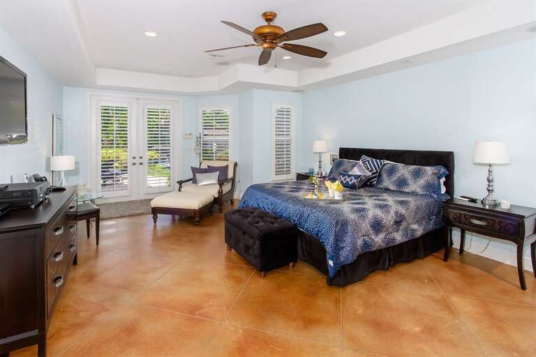 Downstairs primary bedroom features a king size bed, TV and a relaxing reading chair