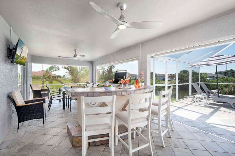 Covered Outdoor Bar with TV and BBQ as well as High Top Bar Seating