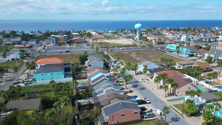 Aerial View Of A Vibrant Village With Distinct Buildings And A Blue Balloon