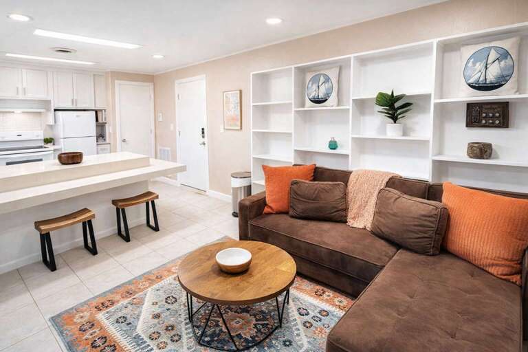 Chic Sofa, Circular Table, Cushioned Stools, And Shelving Symmetry