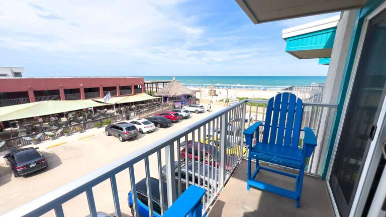 Blue Chair Balcony View Overlooking Bustling Beach Scene