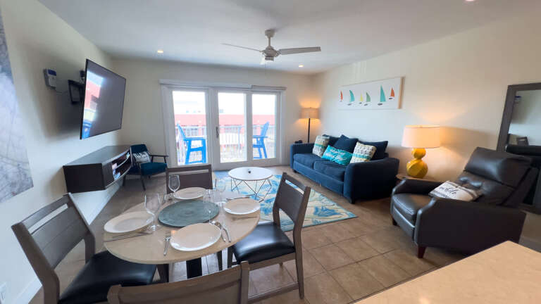 Spacious Living Space With Sofas, Dining Table, And Balcony Access