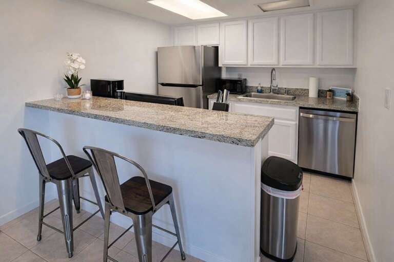 Sleek Stainless Steel Kitchen With Stools And Sink
