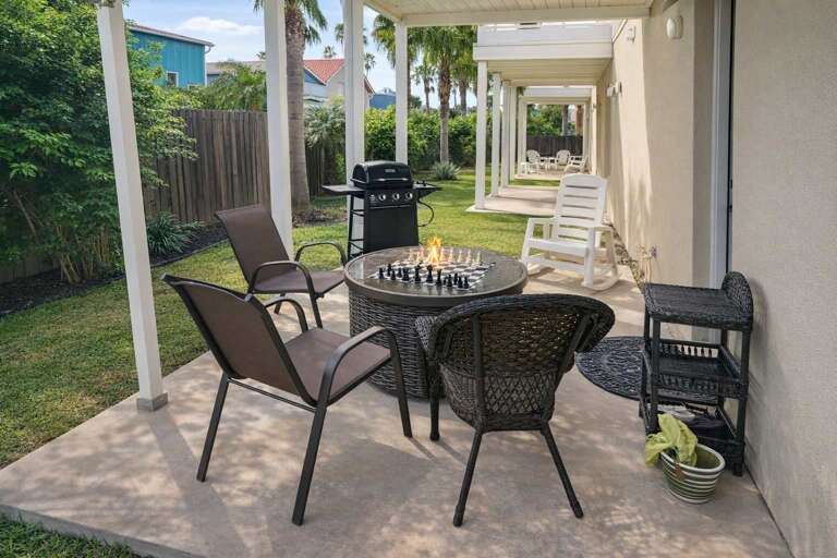 Patio With Chairs, Chess Set, Grill, And Garden