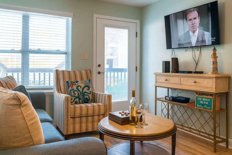 Living Room With Sofa, Armchair, TV, And Round Table