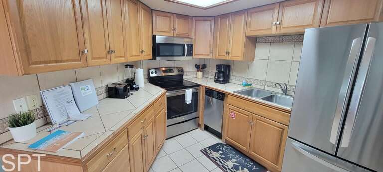 Kitchen Space Sporting Stainless Steel, Surrounded By Wooden Cabinetry