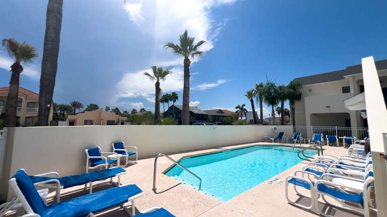 Poolside Paradise With Palms And Plentiful Chairs Under Blue Skies