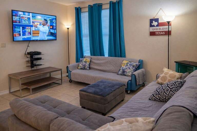 Living Room With Sofas, TV, And Blue Curtains