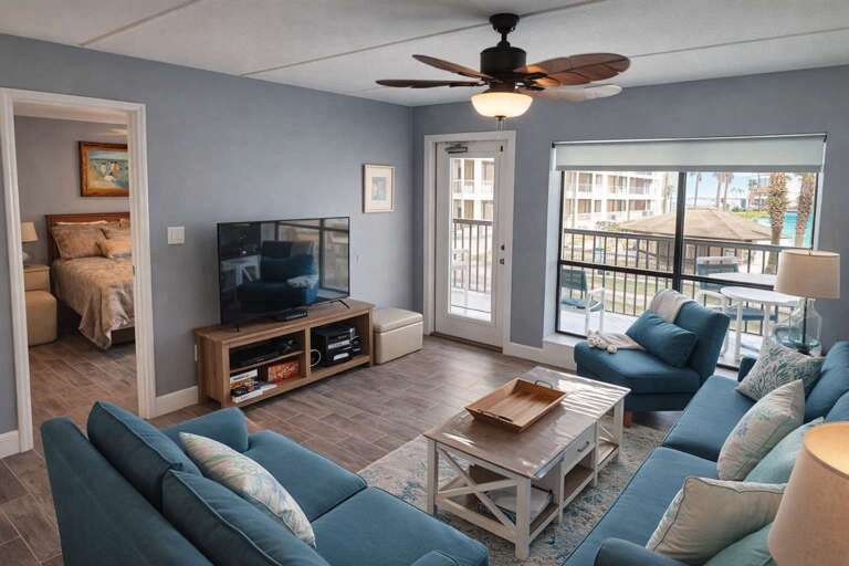 Living Room With Blue Sofas, TV, Ceiling Fan, Balcony View