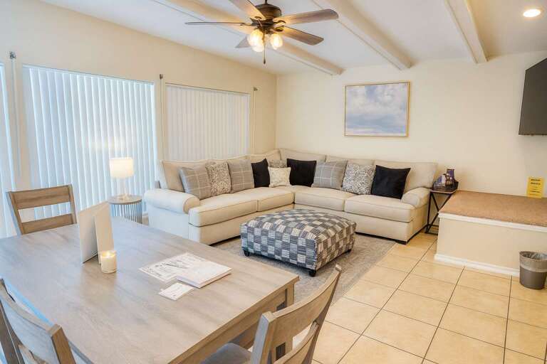 Bright Room, Beige Sectional, Ceiling Fan, Tiled Floor, Dining Table