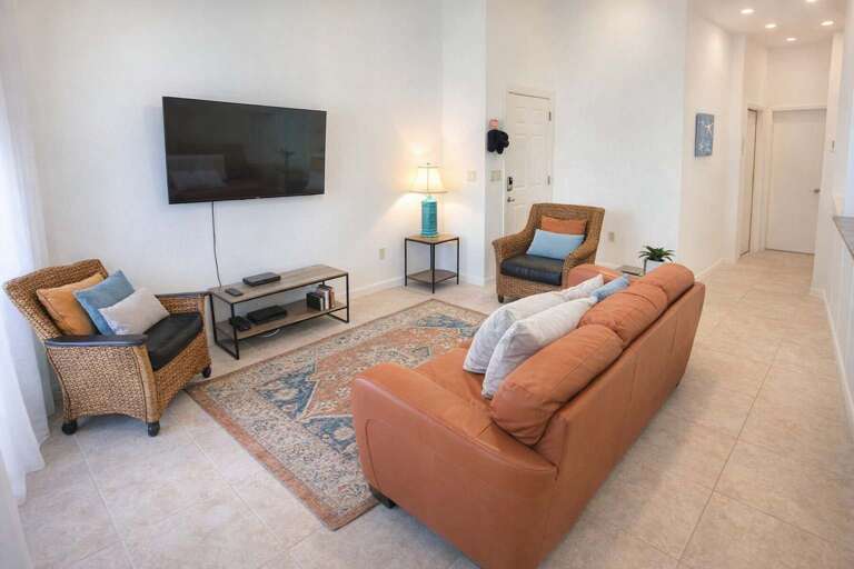 Bright Living Room With Sofa, Chairs, TV, And Rug
