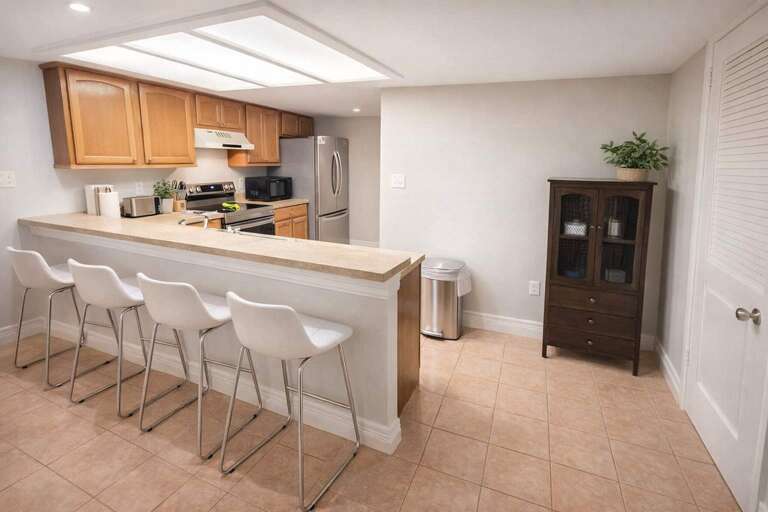 Kitchen With Counter, Chairs, Cabinets, And A Cupboard