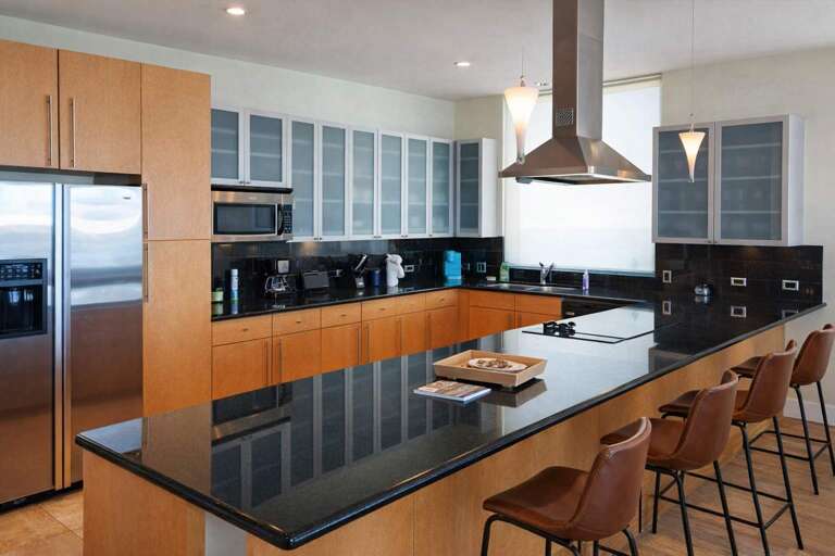 Sleek Kitchen With Stainless Steel, Spacious Countertops, And Stylish Seating