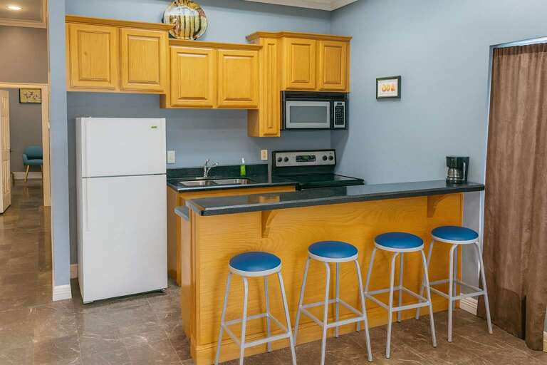 Kitchen Corner With Counter, Stools, And Appliances