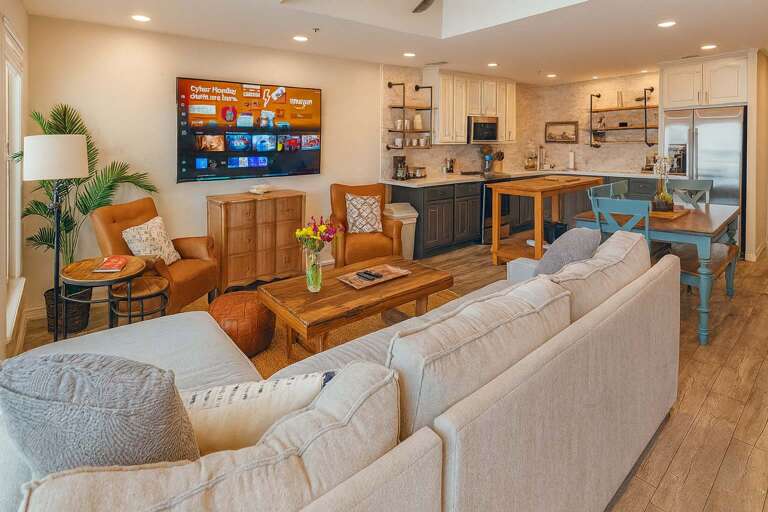 Open-plan Living Room With Sofas, Chairs, Kitchen, And TV