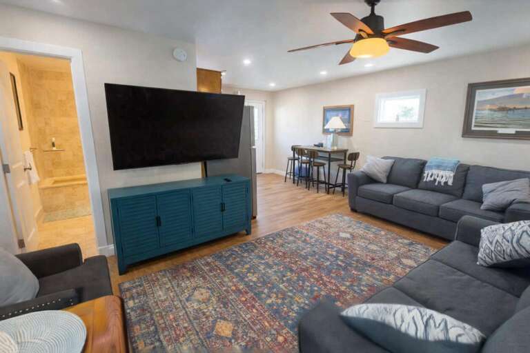 Living Room With Sofas, TV, Ceiling Fan, And Dining Area