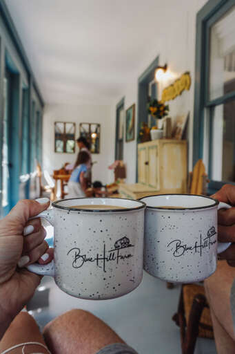 Mugs Meet On A Porch With People In The Background