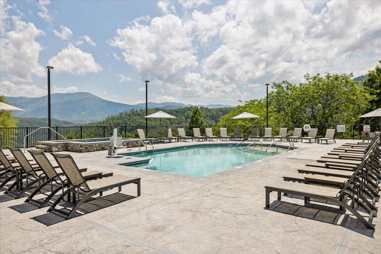 Poolside Loungers Line Mountain Vista View Under Cloudy Skies