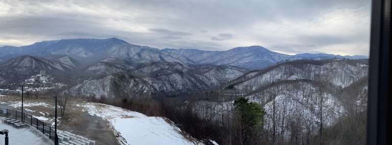 Panoramic View Of Snowy Peaks And Valleys Under Cloudy Skies