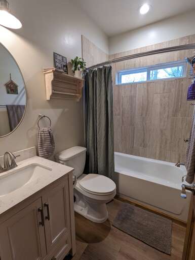 The guest bathroom has a tub and shower combo