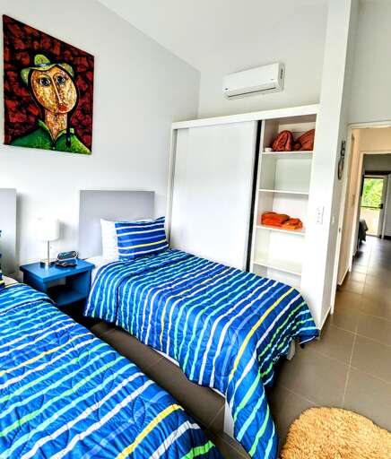 Guest bedroom 2 with two twin beds and ample closet space