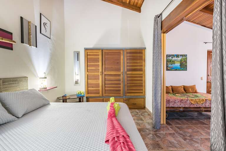 Queen sized bed and Extra bed in living room in Plumeria
