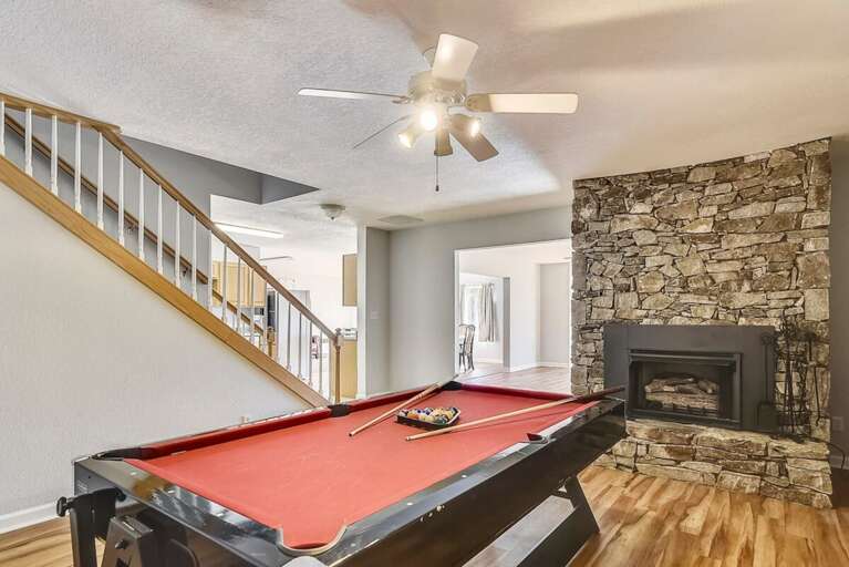 Interior View With Billiard Table, Stone Fireplace, And Wooden Floors