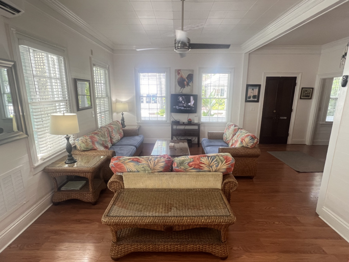 "Relax in this bright, comfortable living room with plenty of seating and a laid-back, tropical style. It's an ideal spot to unwind, watch TV, or spend time with friends and family.