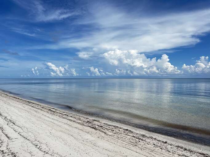 Enjoy a serene walk along the beach, mere steps from your condo.