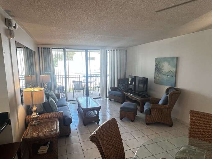 Relax in this bright, open living area with comfortable seating and a view that leads right out to the patio. Perfect for unwinding after a day at the beach or enjoying a quiet evening.
