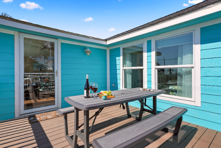 Blue Bungalow Balcony With Outdoor Dining Setup Under Sunny Skies Blue Bungalow Balcony With Outdoor Dining Setup Under Sunny Skies