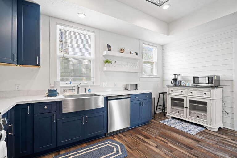 Blue Cabinets Beneath Bright White Walls In Kitchen