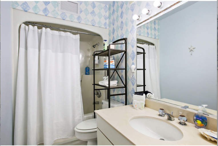 Bathroom is stocked with shampoo, conditioner, body wash, hair dryer, towels, and hand soap.