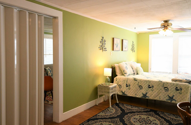 Bedroom on second floor, with queen bed, en-suite bathroom, desk and chair.