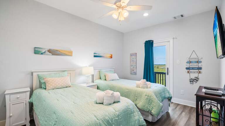 Bedroom 2 w/ twin size beds, patio access, and TV.