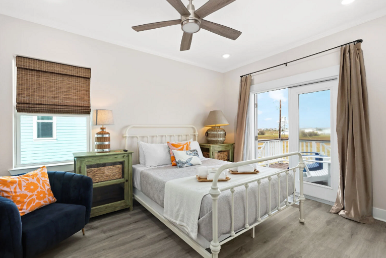 Lovely queen bedroom with double doors opening to deck, with ocean view. A great place to start your day!  This bedroom is directly across the hall from the master.