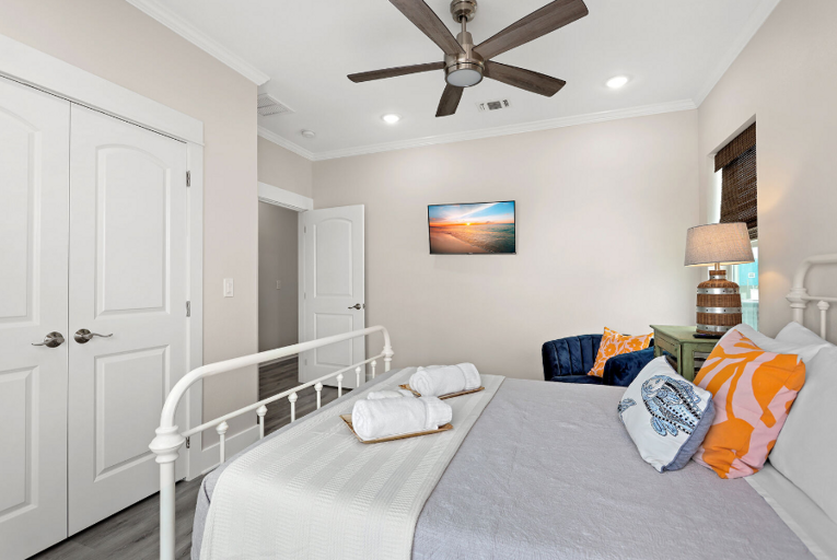 Queen bedroom with streaming TV, double doors to the deck offering an ocean view.