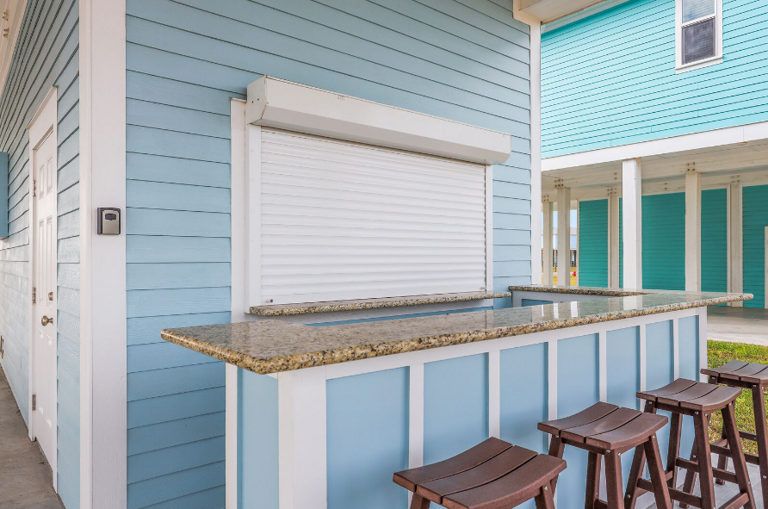 Roll up the door and enjoy this great outdoor bar space! Mini frig inside along with a grill and beach accessories.