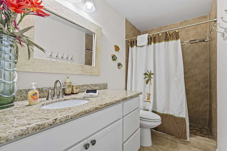 Clean, bright bathroom with a spacious walk-in shower — perfect for refreshing after the beach.