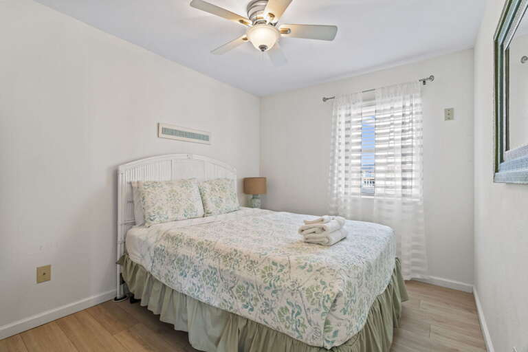 Peaceful, sunlit bedroom with cozy coastal comfort — restful nights guaranteed.