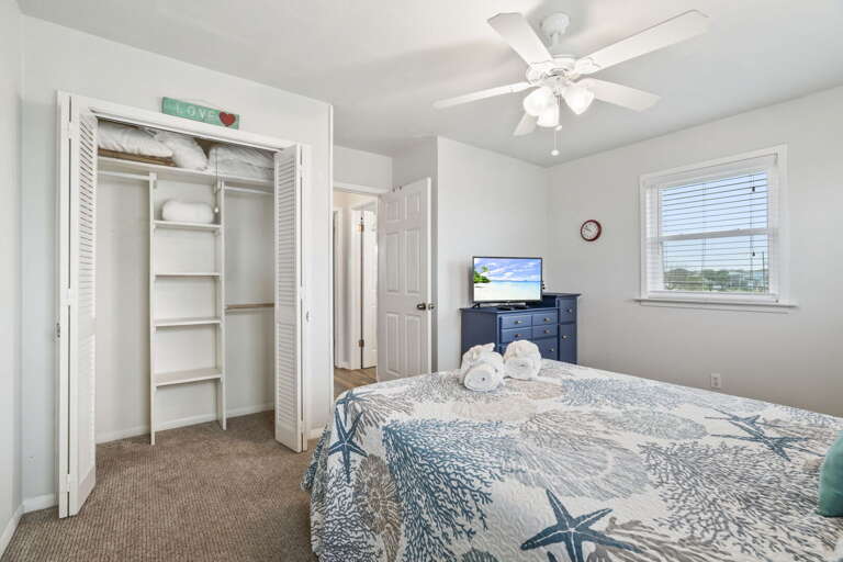 Peaceful bedroom with a comfortable queen bed, TV for relaxing evenings, and convenient closet storage.