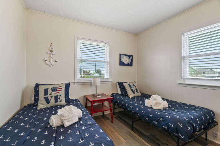 Twin bedroom with cozy beds and nautical-inspired décor.