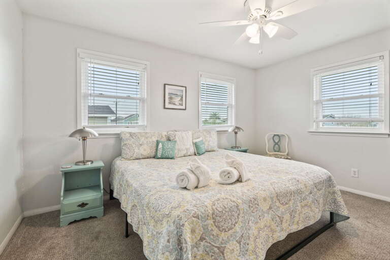 Unwind in this light-filled bedroom featuring a cozy king bed and soft coastal touches.