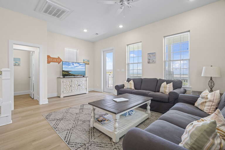 Cozy coastal living room with plenty of natural light and a comfy space to unwind after a day at the beach.