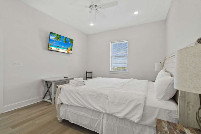 Inviting bedroom with a cozy bed and TV, perfect for relaxing after a beach day.